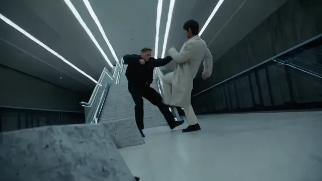 Two performers facing one another on a concrete stairway in an action scene